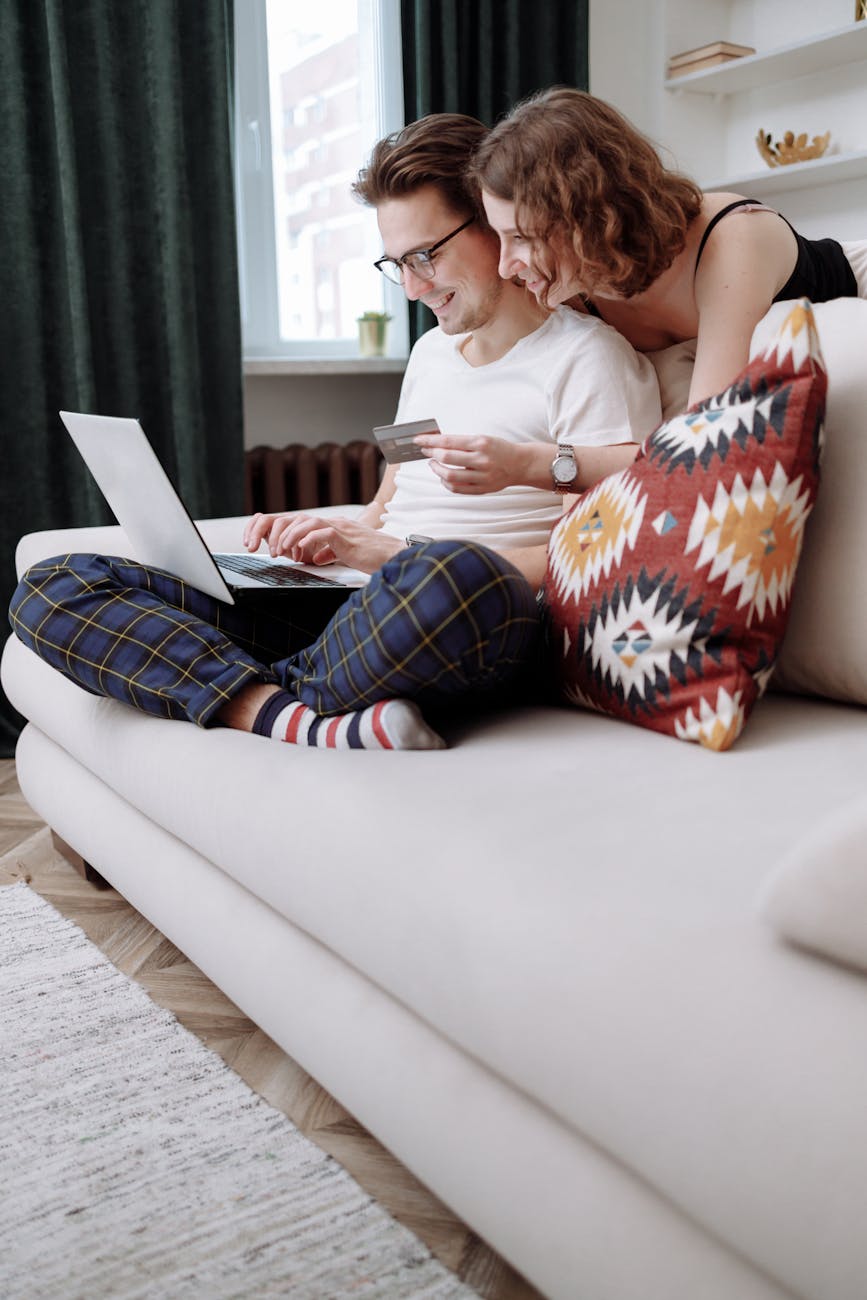 man and woman smiling while shopping online