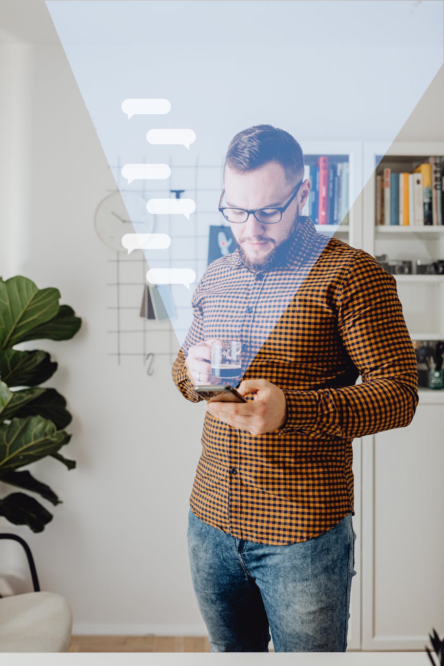 man using his phone while drinking coffee